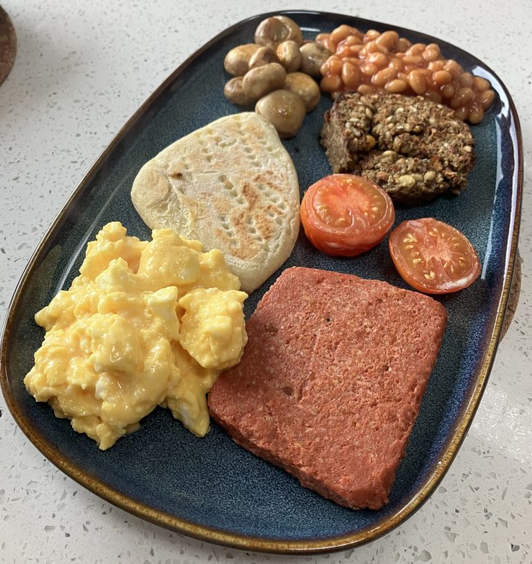 Veggie cooked breakfast with vegan lorne sausage and vegan Haddis. Mushrooms, baked beans, tattie scones and scrambled eggs