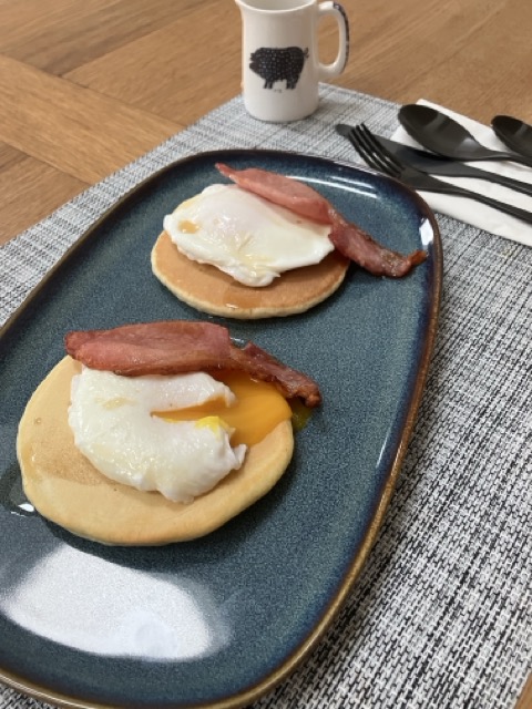 Breakfast pancakes with poached eggs, crispy bacon, and maple syrup at Craighall Steading B&B.